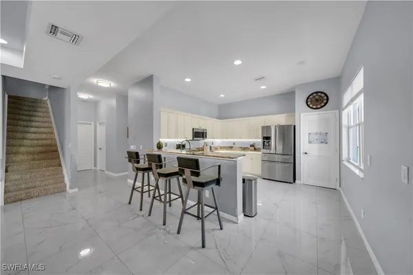 a kitchen with a dining table chairs and white cabinets
