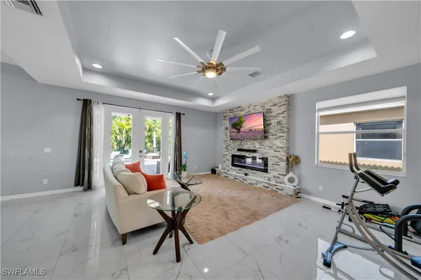 a living room with furniture a flat screen tv and a large window