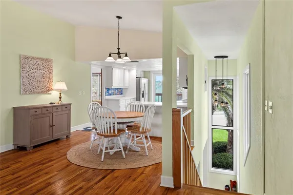 a dining room with furniture a chandelier and wooden floor
