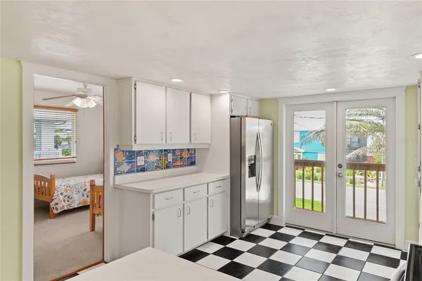 a kitchen with a refrigerator and white cabinets