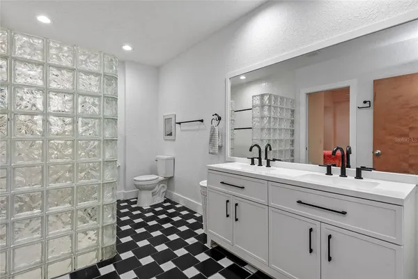 a bathroom with a double vanity sink mirror and toilet