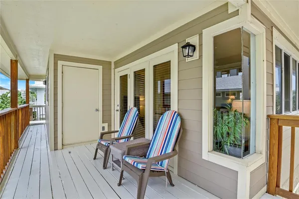 a view of a balcony with furniture and large windows