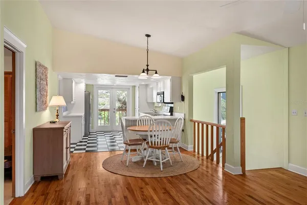 a dining room with furniture a chandelier and wooden floor