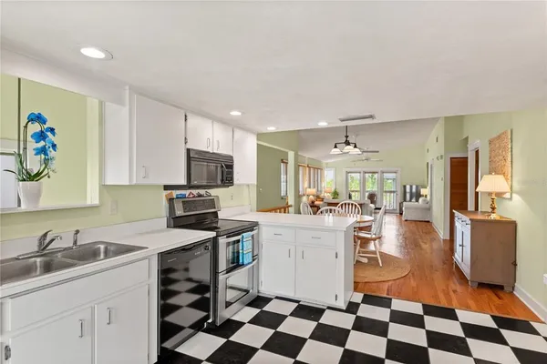 a kitchen with a sink a stove a microwave and cabinets