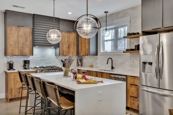 a kitchen with stainless steel appliances a stove a refrigerator and a chandelier