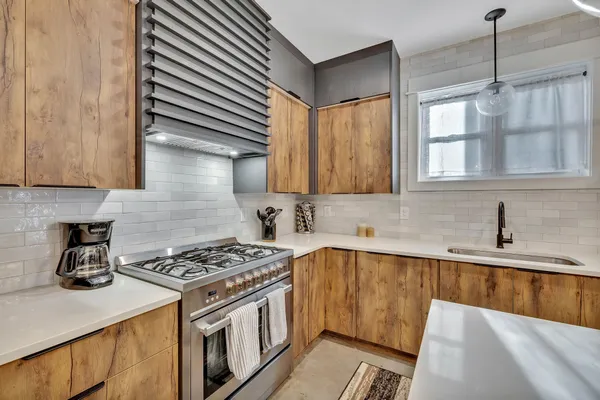 a kitchen with stainless steel appliances granite countertop a sink stove and cabinets