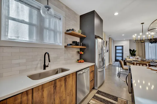 a kitchen with stainless steel appliances granite countertop a sink refrigerator and cabinets