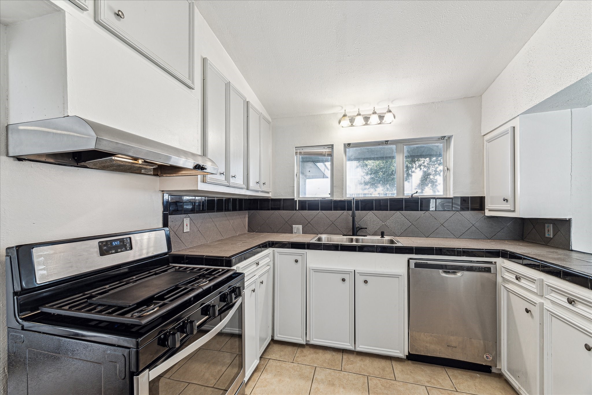 5125 Maple Street Bellaire, TX 77401 - Photo 8 of 14 a kitchen with a sink stove and cabinets