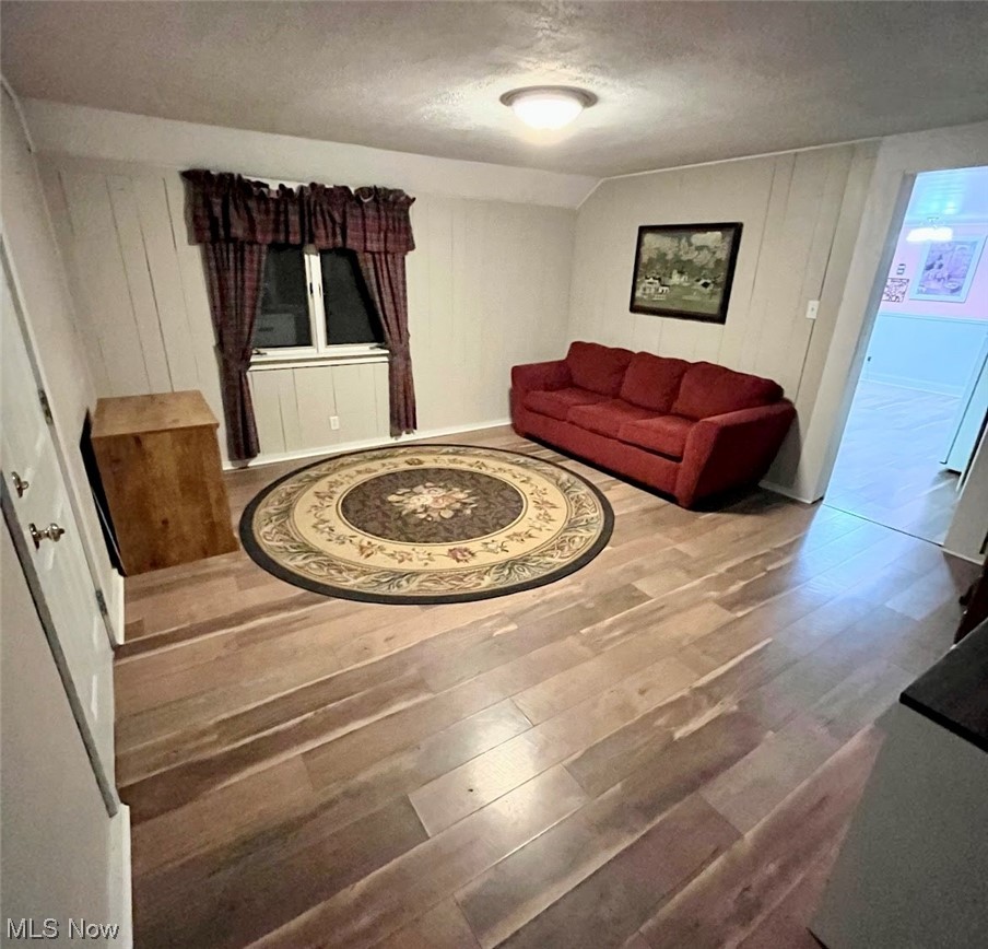 4091 Lynn Road Ravenna, OH 44266 - Photo 11 of 23 Living room with a textured ceiling, vaulted ceiling, and hardwood / wood-style flooring