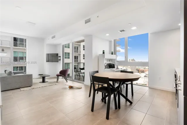 a living room with a table chairs and a kitchen island