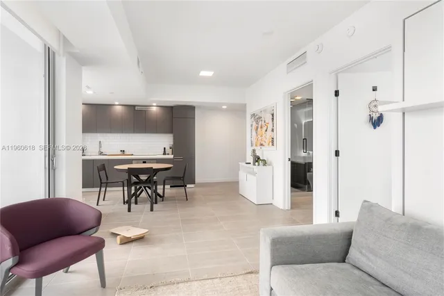 a living room with furniture and kitchen view