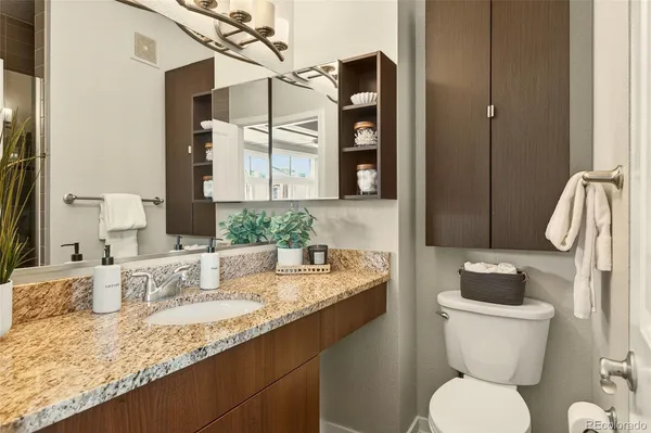 a bathroom with a granite countertop sink toilet and shower