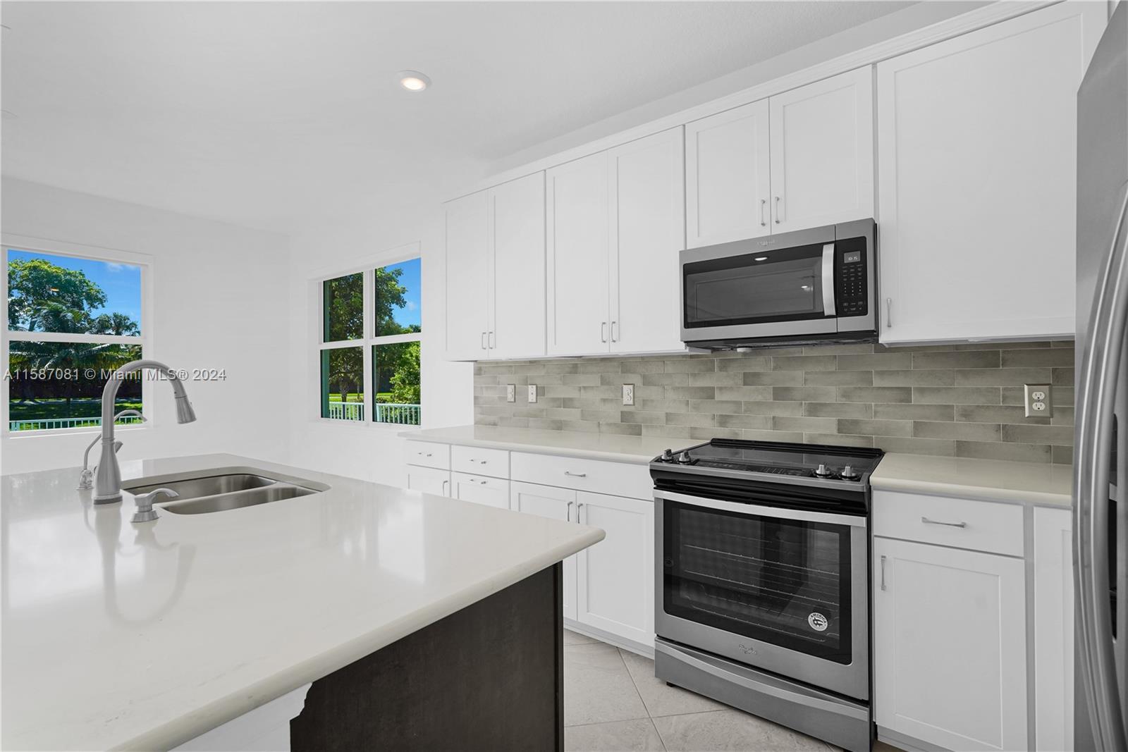 1595 Trailhead Terrace Hollywood, FL 33021 - Photo 18 of 49 a kitchen with granite countertop a stove microwave and sink
