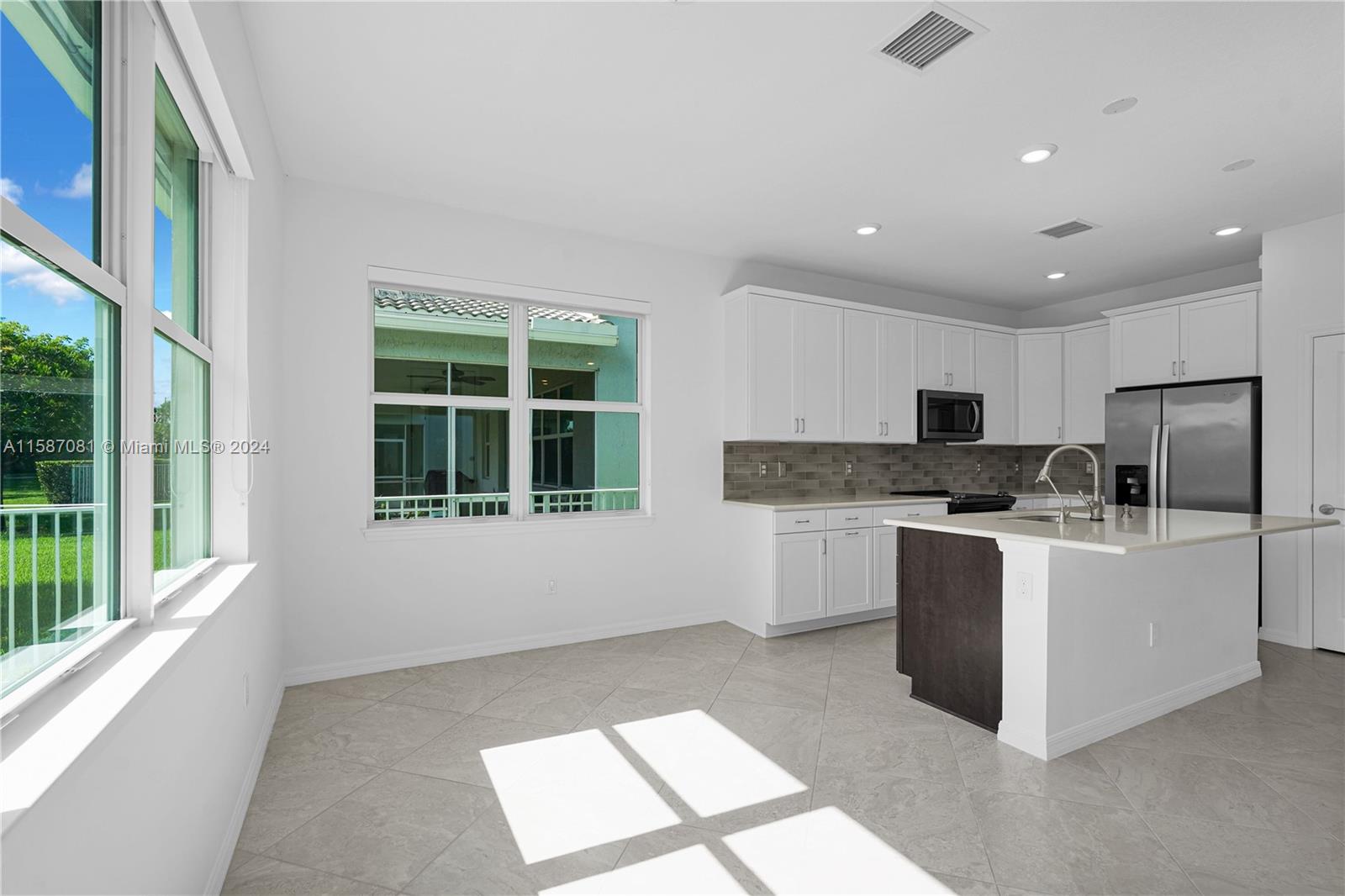 1595 Trailhead Terrace Hollywood, FL 33021 - Photo 10 of 49 a large white kitchen with kitchen island a large window in it and a sink