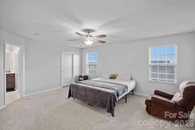 a spacious bedroom with a bed a couch and a chandelier