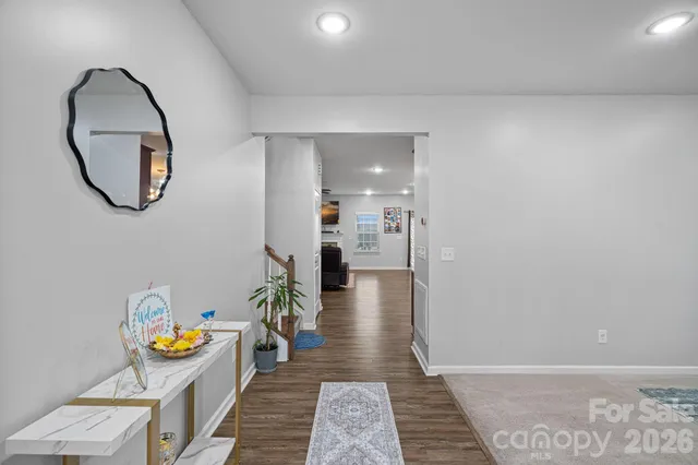 a view of a hallway with wooden floor and a potted plant