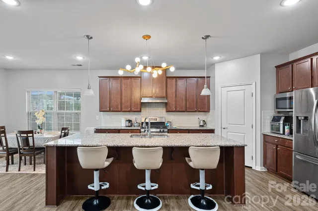 a kitchen with stainless steel appliances granite countertop a sink stove and cabinets