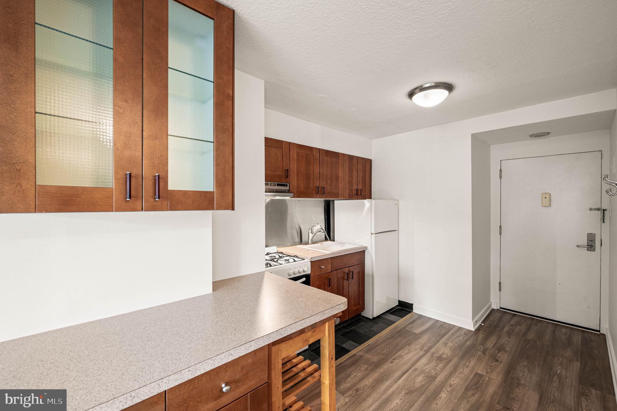 604 South Washington Square, Unit 418 Philadelphia, PA 19106 - Photo 4 of 22 a kitchen with a sink dishwasher a stove and a refrigerator with wooden floor