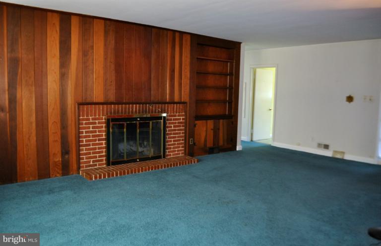 7915 Ruxway Road Towson, MD 21204 - Photo 8 of 14 an empty room with a fireplace and cabinet