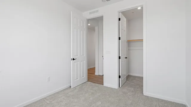 an empty room with a hallway and a shower