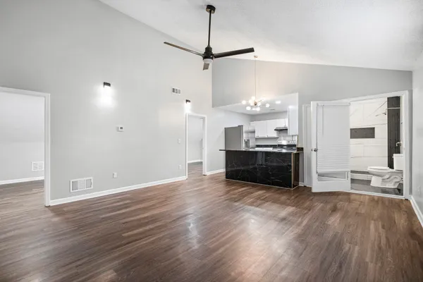 a view of a kitchen with a stove wooden cabinets and entryway