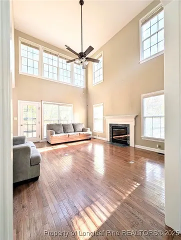 a living room with stainless steel appliances furniture a rug and a view of kitchen
