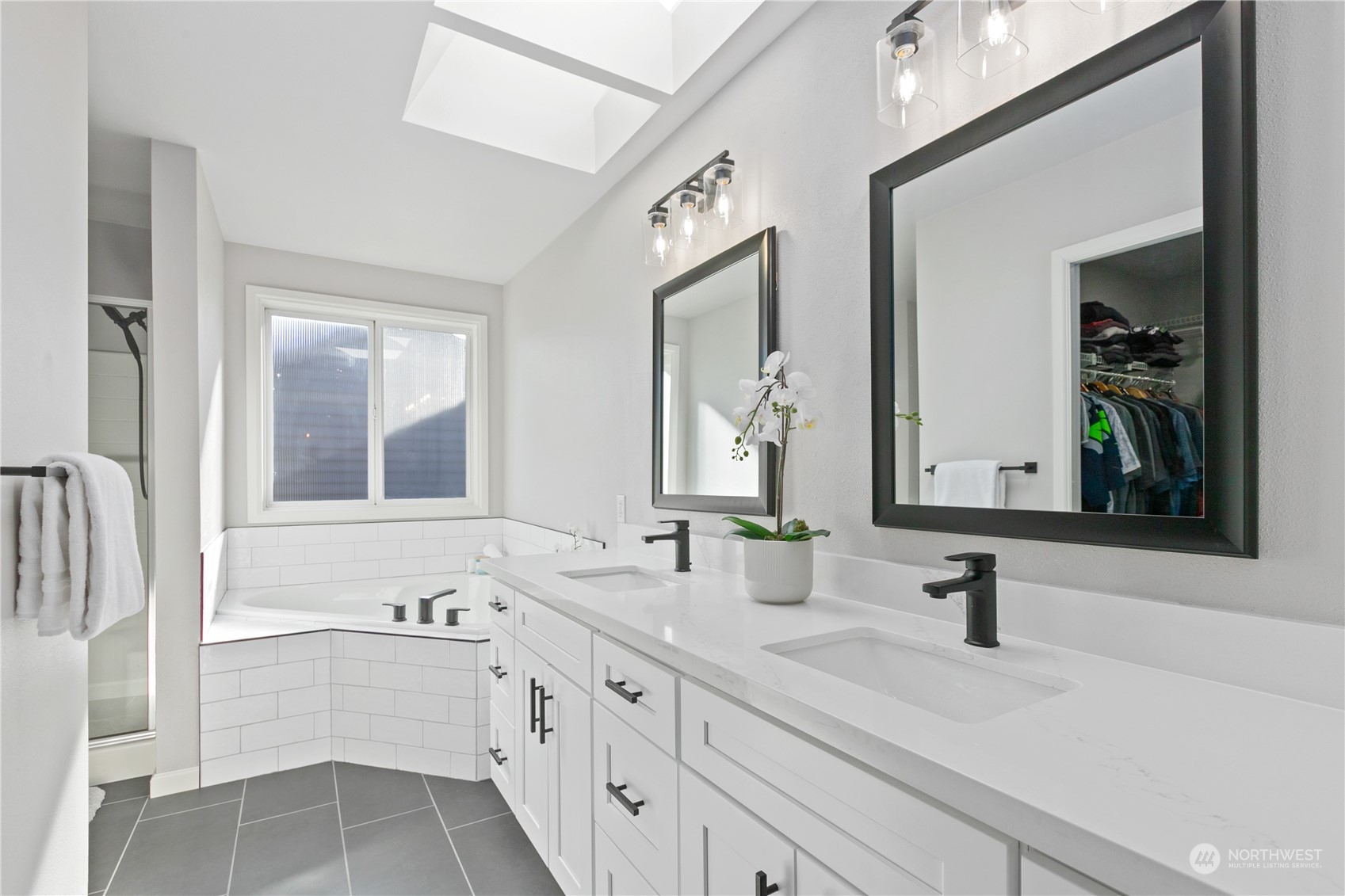 18205 27th Drive Southeast Bothell, WA 98012 - Photo 23 of 37 a bathroom with double vanity sinks a large mirror and a bathtub