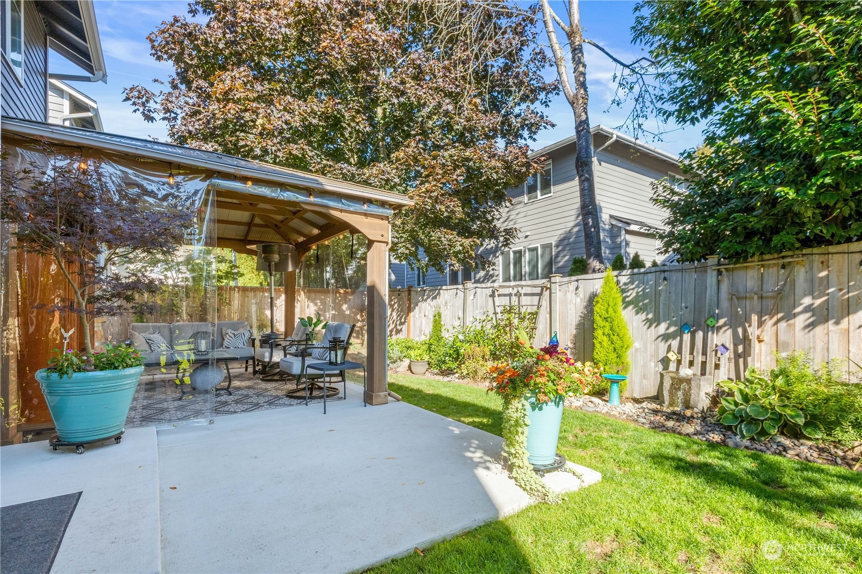 18205 27th Drive Southeast Bothell, WA 98012 - Photo 33 of 37 a view of a patio with table and chairs potted plants and a large tree