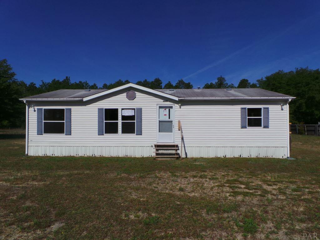 5049 Bodega Road Milton, FL 32583 - Photo 1 of 23 a front view of a house with a garden