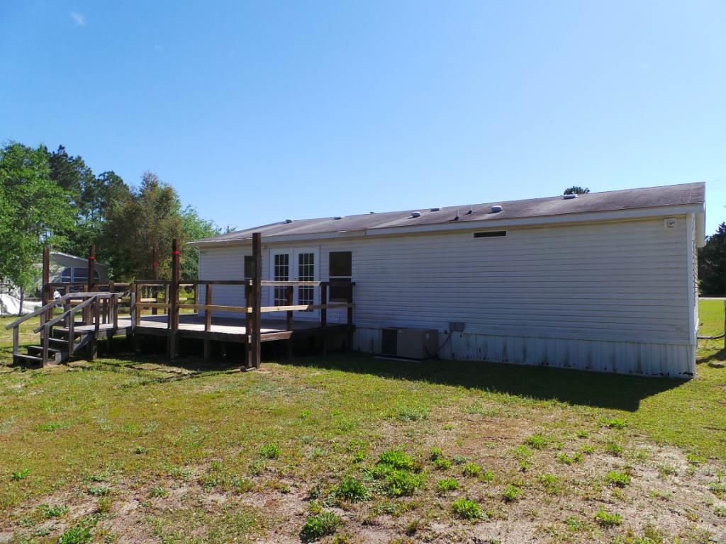 5049 Bodega Road Milton, FL 32583 - Photo 4 of 23 a backyard of a house with wooden fence and large trees