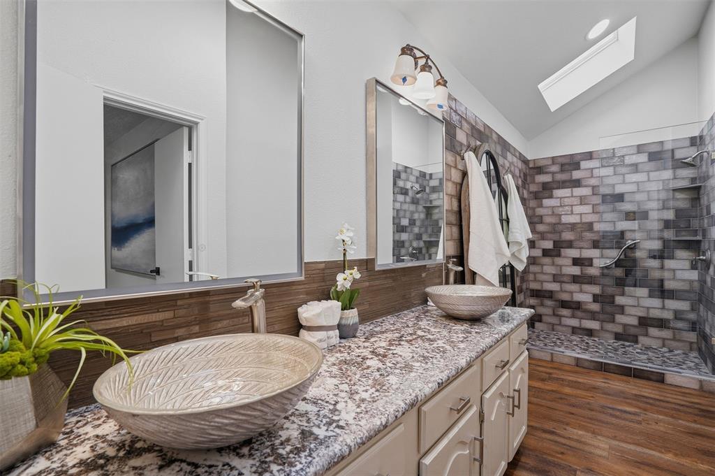6500 Spur Ranch Court Plano, TX 75023 - Photo 12 of 32 a bathroom with a granite countertop sink and a mirror