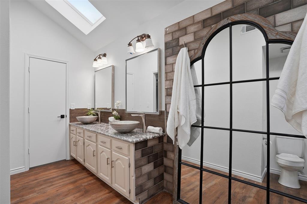 6500 Spur Ranch Court Plano, TX 75023 - Photo 13 of 32 a bathroom with a double vanity sink and mirror