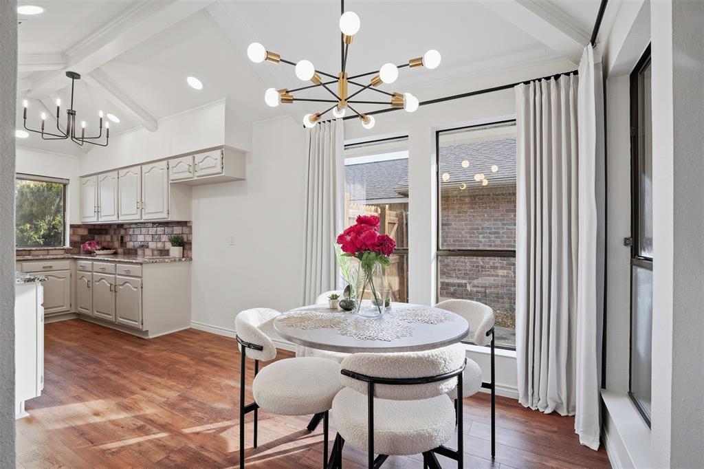 6500 Spur Ranch Court Plano, TX 75023 - Photo 6 of 32 a kitchen with stainless steel appliances a dining table chairs and chandelier