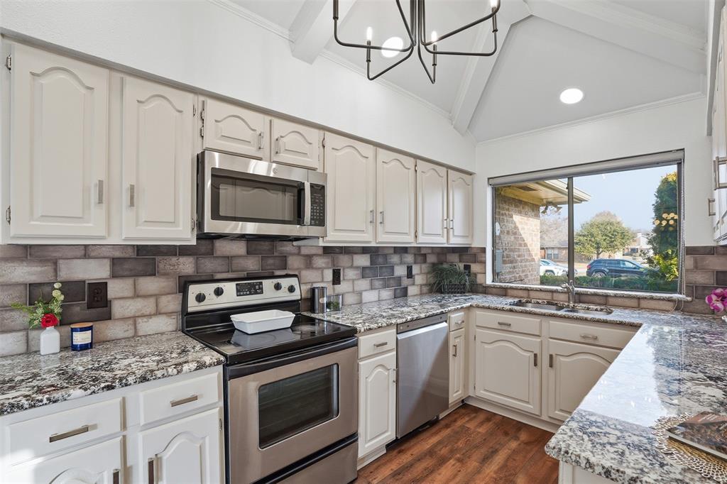 6500 Spur Ranch Court Plano, TX 75023 - Photo 8 of 32 a kitchen with stainless steel appliances granite countertop a sink a stove and cabinets