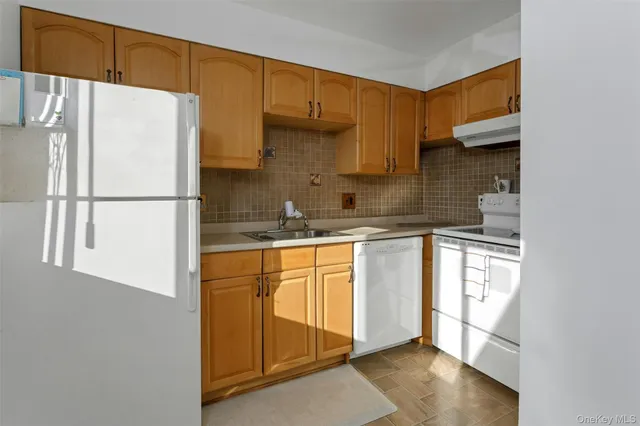 a kitchen with a refrigerator a sink and cabinets