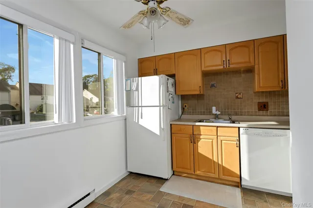 a kitchen with stainless steel appliances a refrigerator and a chandelier