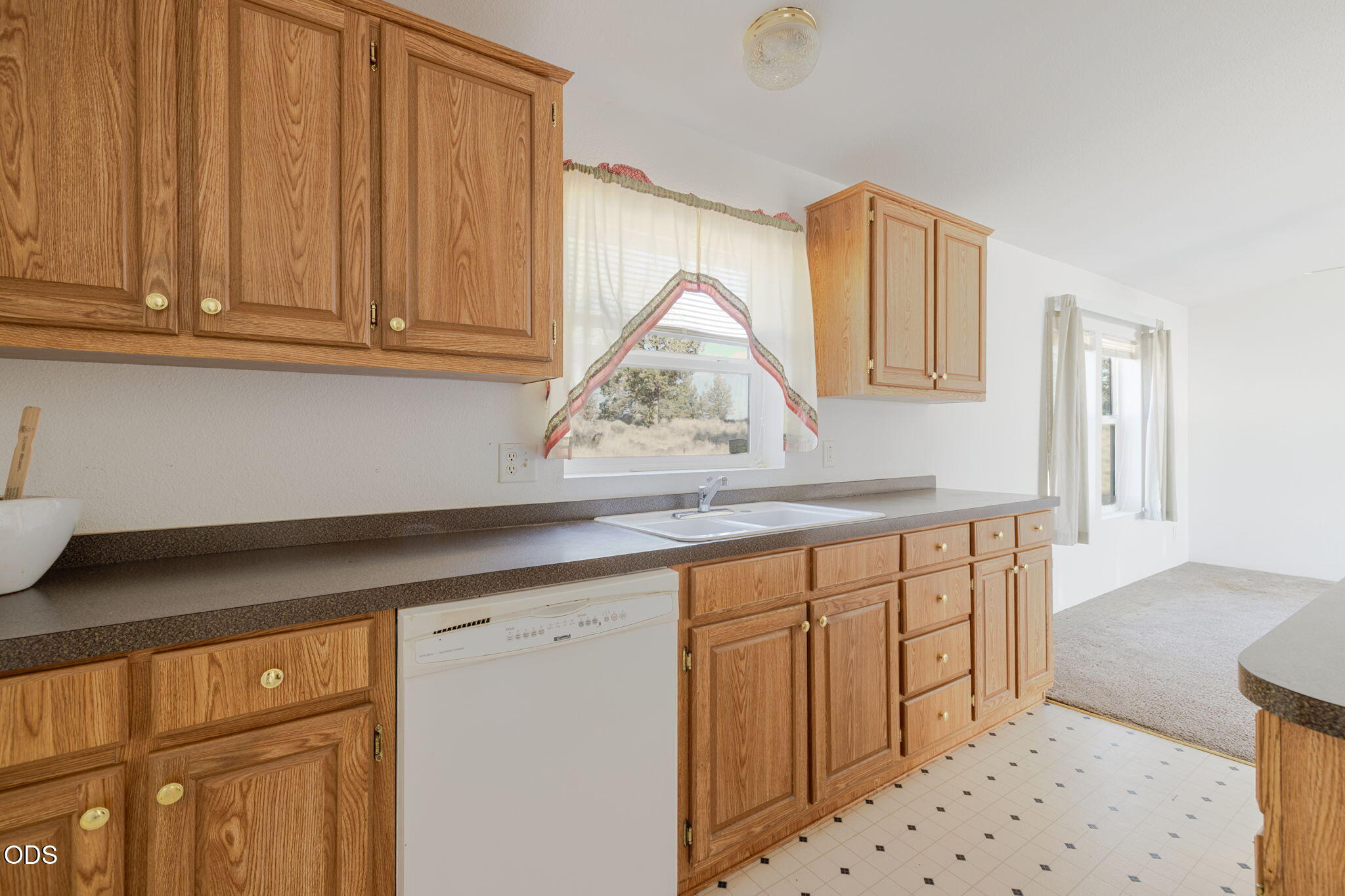8628 Southwest Crater Loop Road Terrebonne, OR 97760 - Photo 17 of 36 a kitchen with granite countertop white cabinets and sink