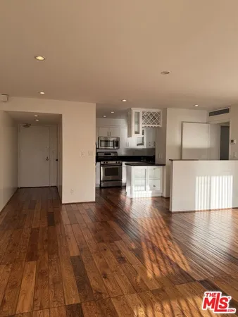 a kitchen with stainless steel appliances a refrigerator and wooden floor