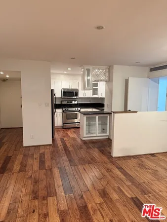 a kitchen with wooden floors and appliances