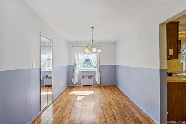 a room with hard wood floors and a chandelier