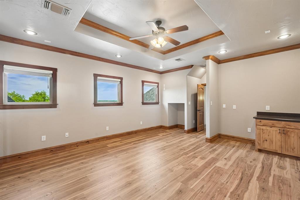 2085 Switzer Road Sanger, TX 76266 - Photo 22 of 39 Spacious room featuring wood-finish flooring, a tray ceiling with recessed lighting, and a ceiling fan
