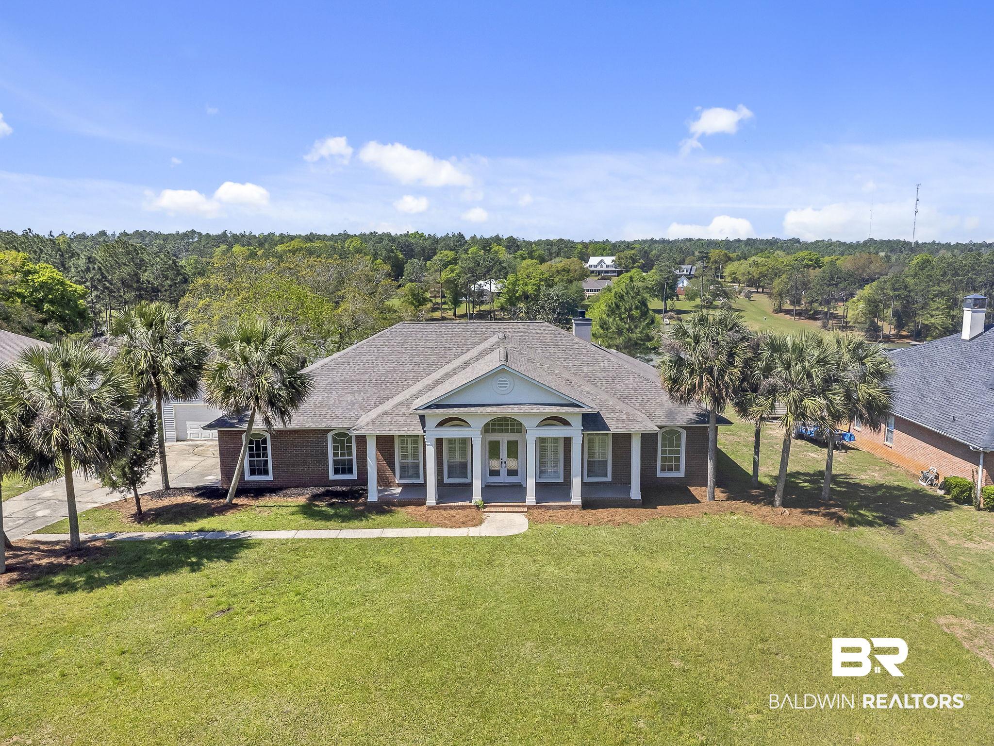 View of front of house featuring a front lawn, a shingled roof, and french doors