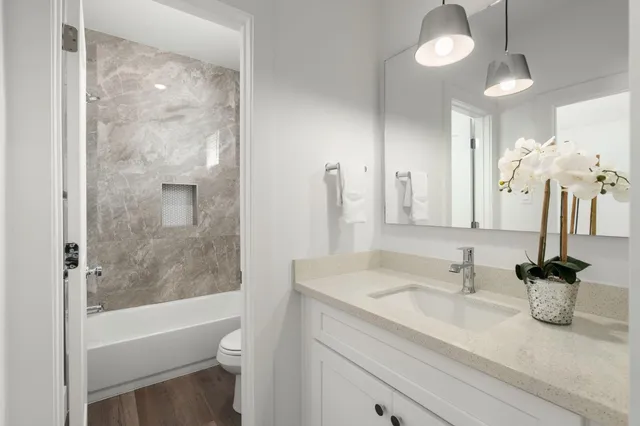 a bathroom with a granite countertop sink a toilet and bathtub