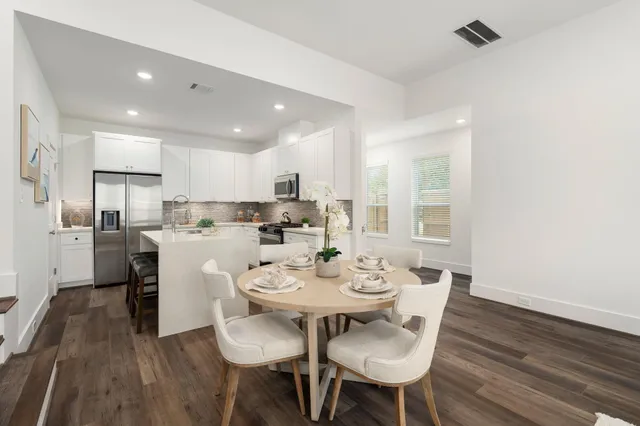 a open dining room with stainless steel appliances kitchen island a table and chairs