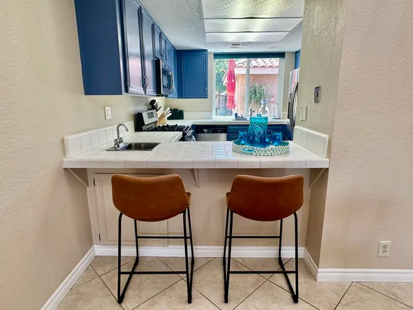 a kitchen with stainless steel appliances a dining table and chairs