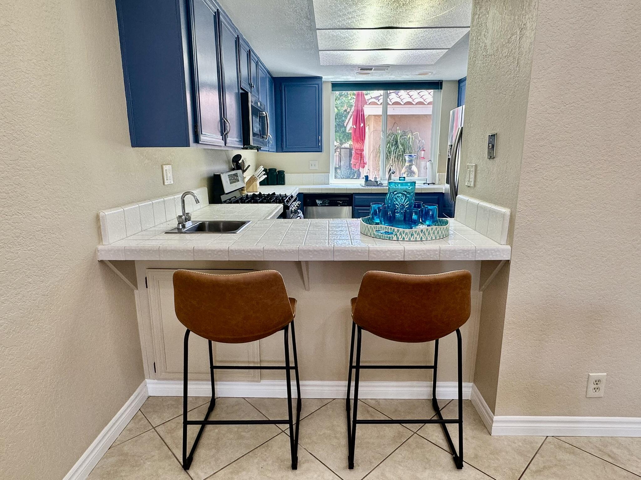 336 Villena Way Palm Desert, CA 92260 - Photo 11 of 19 a kitchen with stainless steel appliances a dining table and chairs