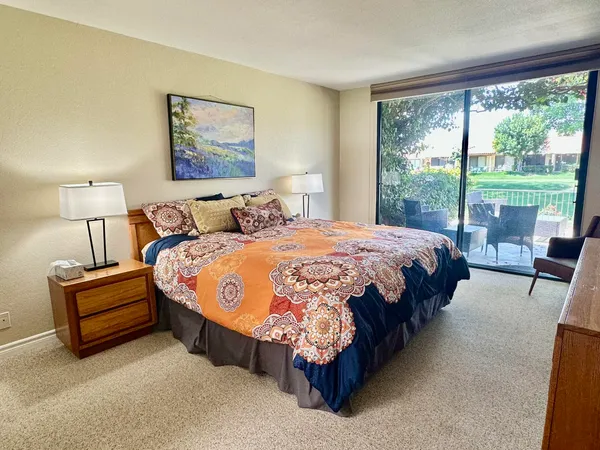 a spacious bedroom with a bed lamp and a large window