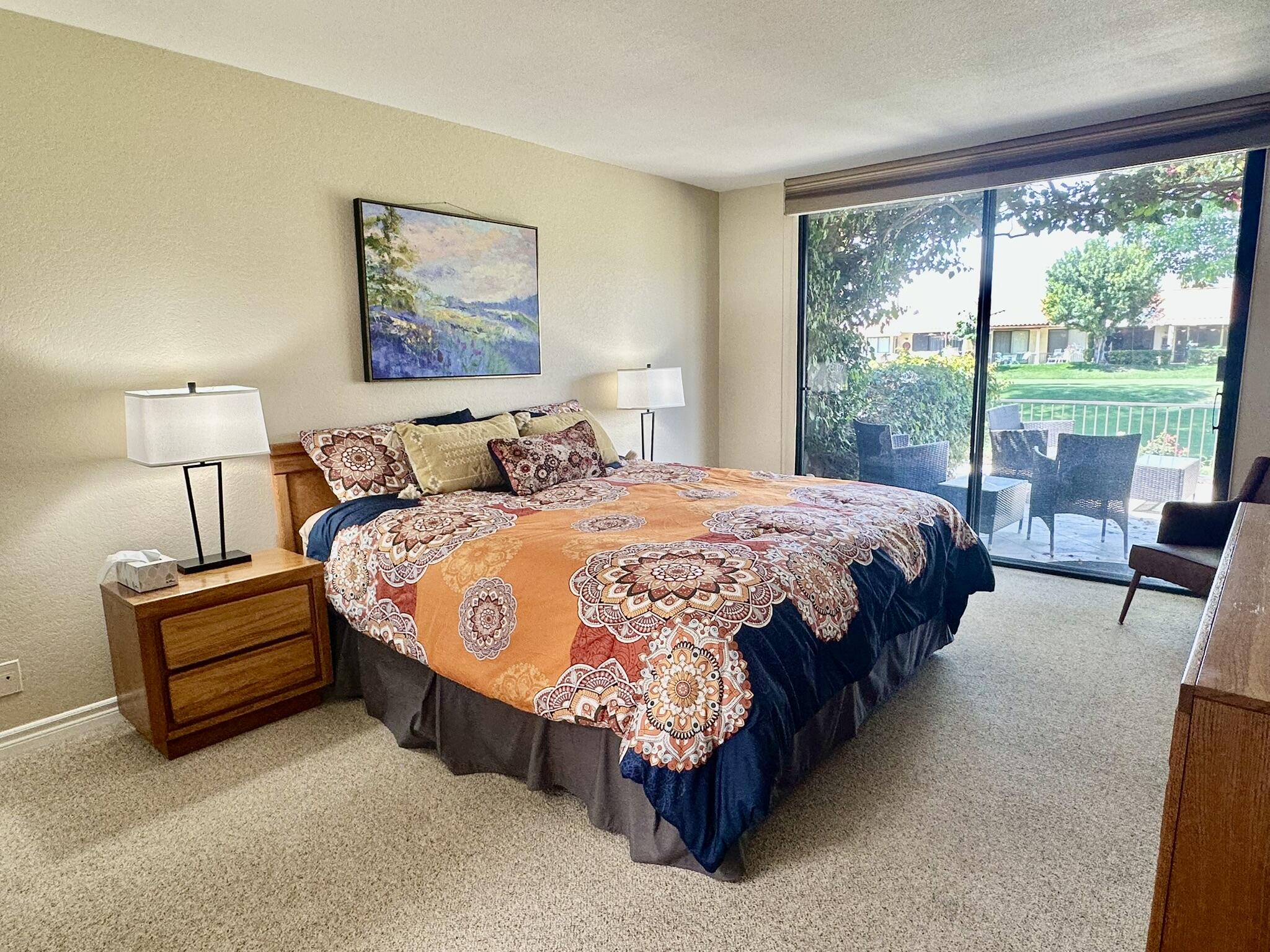 336 Villena Way Palm Desert, CA 92260 - Photo 12 of 19 a spacious bedroom with a bed lamp and a large window
