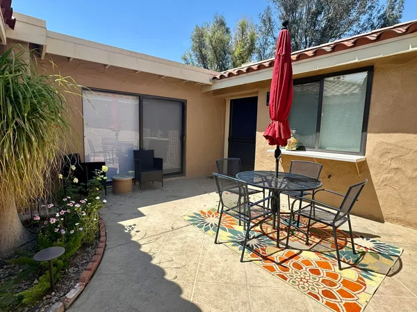 a view of a patio with table and chairs and potted plants