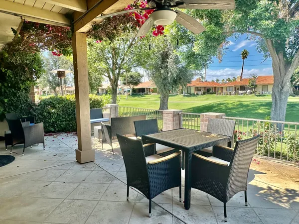 a view of a patio with a table chairs and a backyard